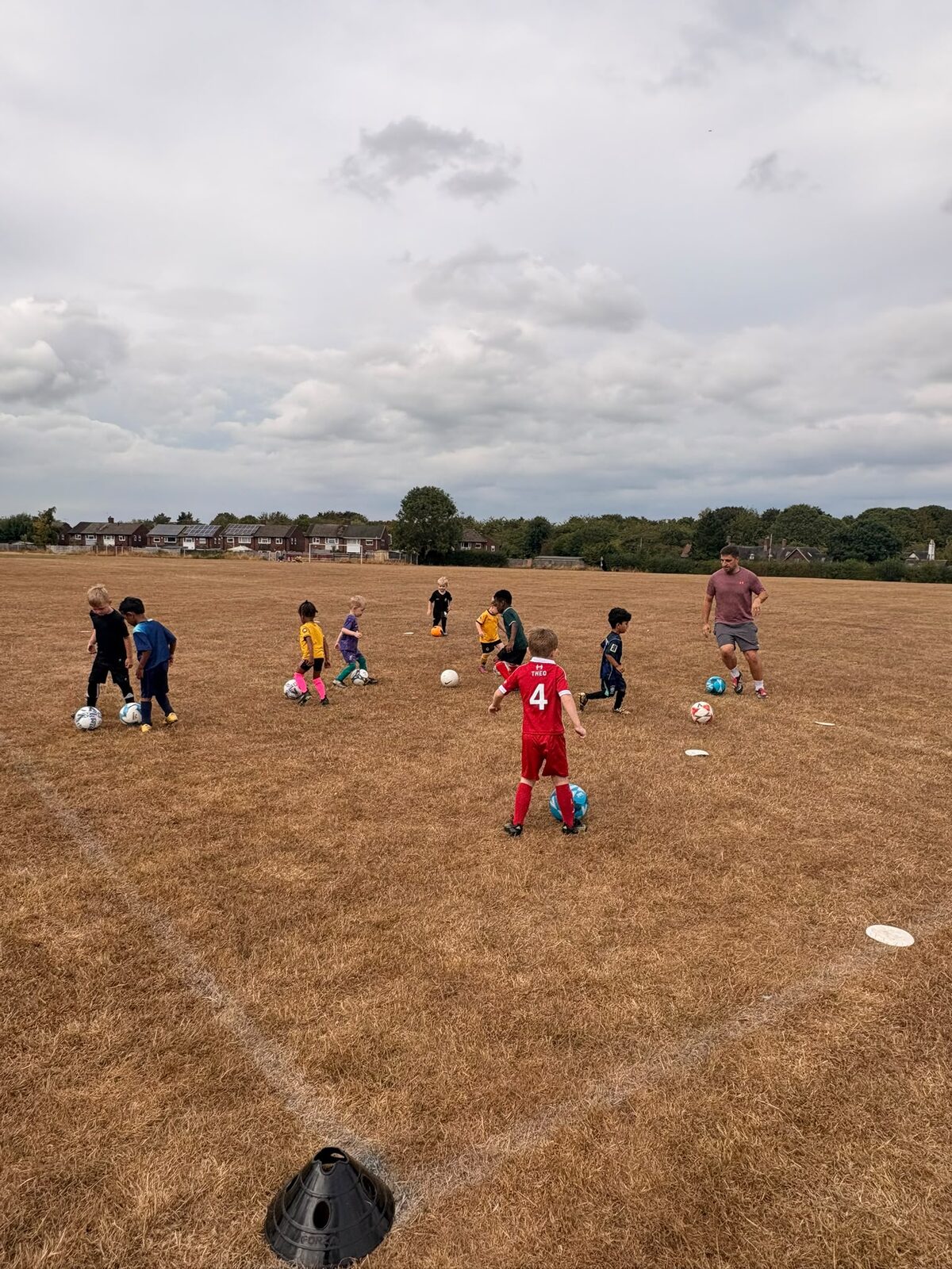 Young children dribbling footballs at an Excel Minis session in Telford