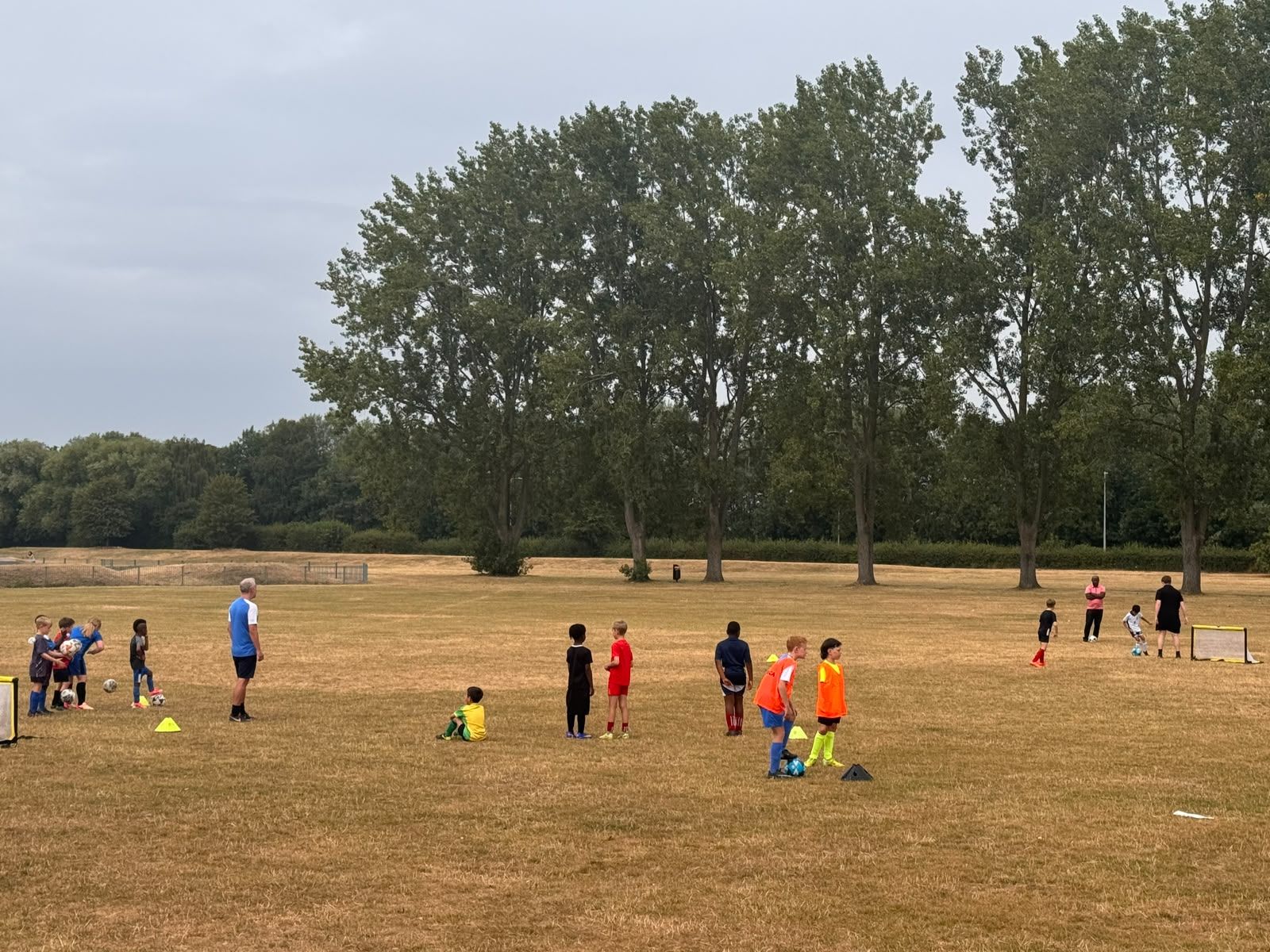 Children training across the field at Excel Coaching